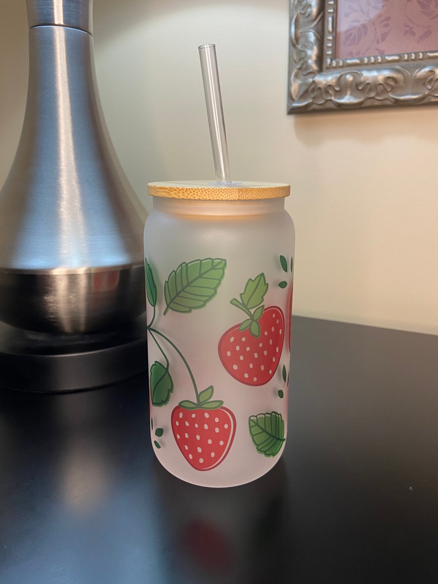 Enjoy your drinks in style with our strawberry Libbey-style 16 oz. frosted glass drink cup with bamboo lid.