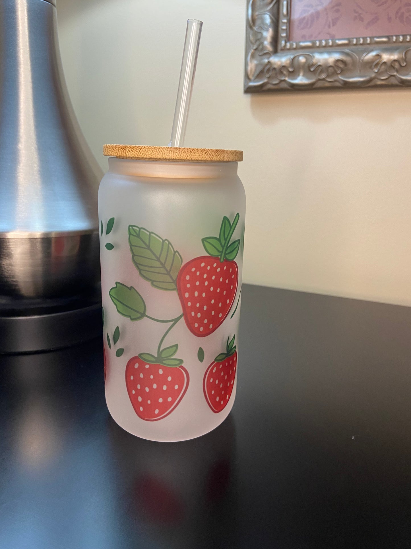 Enjoy your drinks in style with our strawberry Libbey-style 16 oz. frosted glass drink cup with bamboo lid.
